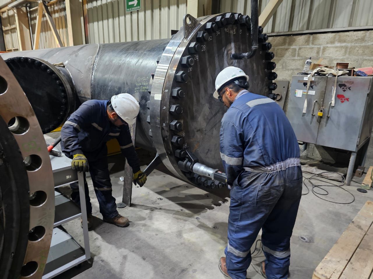 Técnicos de HydroPipe aplicando torque a la unión bridada del cabezal de prueba